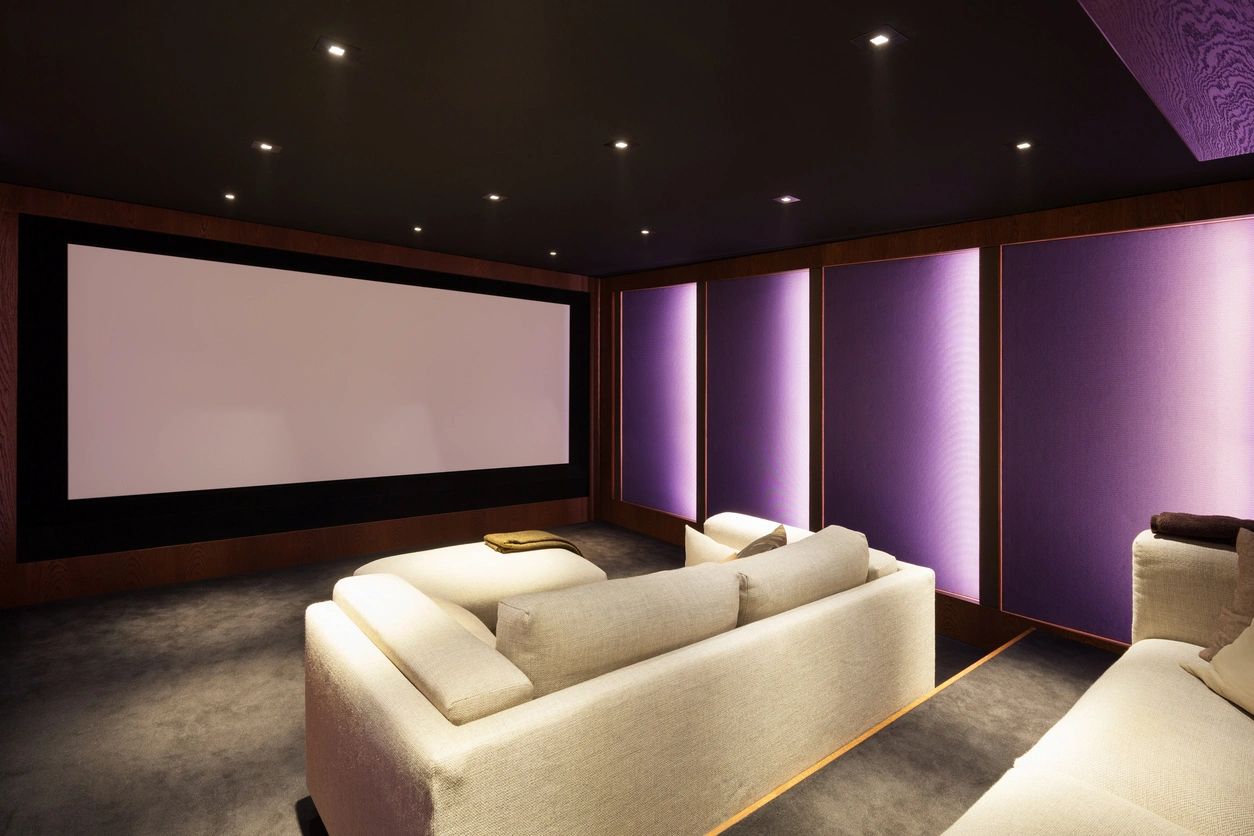 Modern home theater with projection screen and purple accent lighting